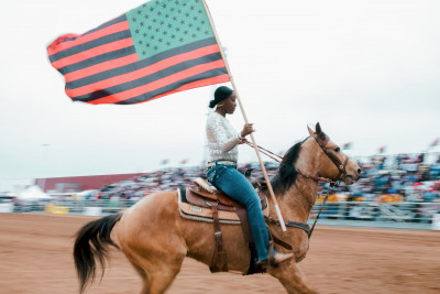 Dayna Carter con la bandera Pan-Africana  en un rodeo en Chandler, Arizona.jpg